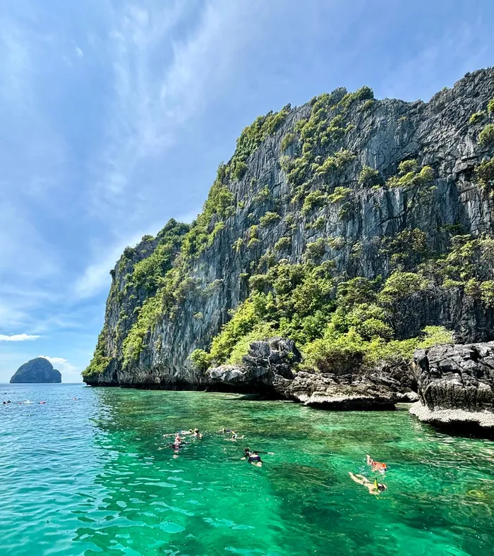 Snorkeling au pied des falaises calcaires, eaux émeraude de la mer d'Andaman